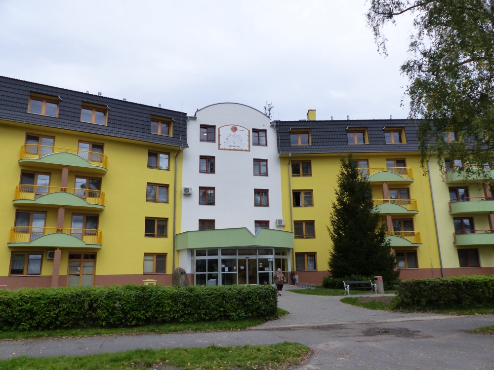 Hlavní vchod do Senior-domu Soběslav se zelenou stříškou a žlutou fasádou