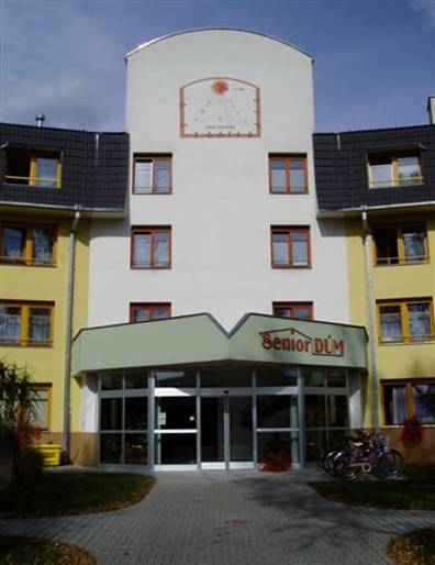 Hlavní vchod do Senior-domu se slunečními hodinami na fasádě